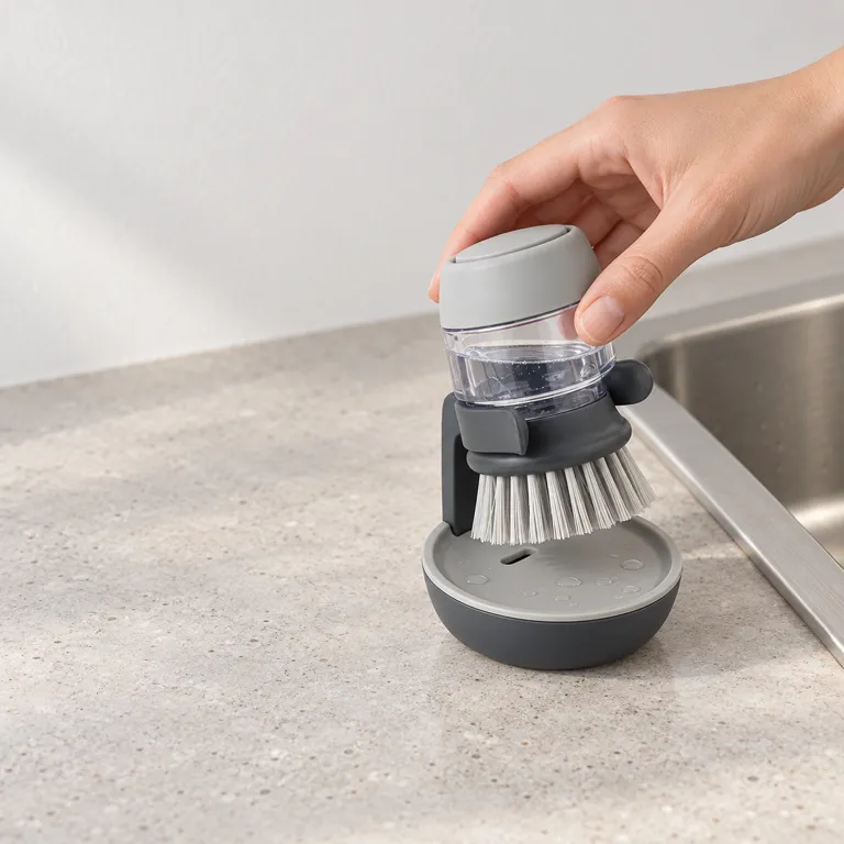 A hand placing the grey brush back on its charcoal stand beside the sink, water droplets on the drip tray.